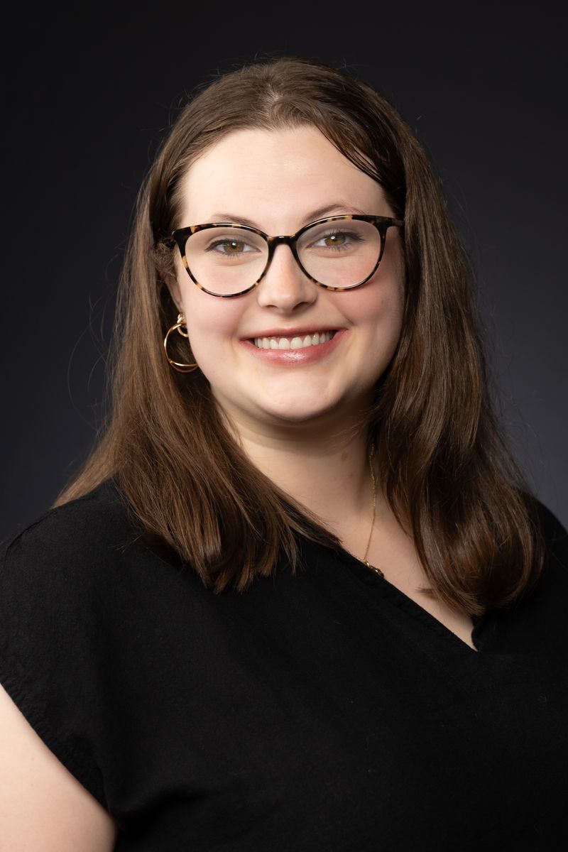 Headshot of a woman with glasses and dark hair