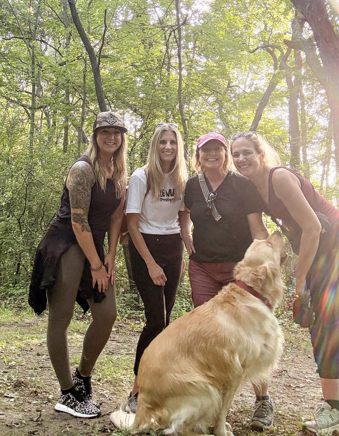 Women laughing together on a wooded trail